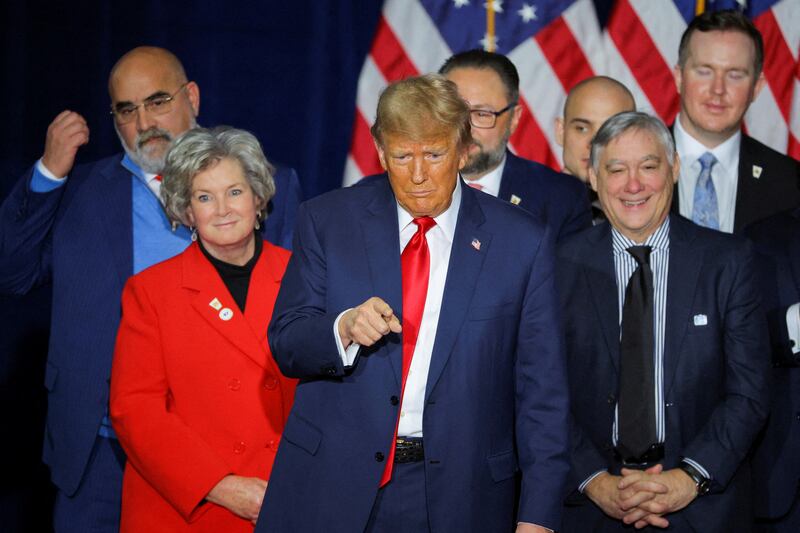 Republican presidential candidate and former U.S. President Donald Trump gestures as he stands with Chris LaCivita, Susie Wiles, Jason Miller, John Brabender and other campaign officials