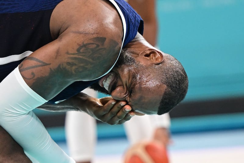 LeBron James winces and holds his head in pain after being elbowed during the quarterfinal between USA and Brazil at the Olympic Games.