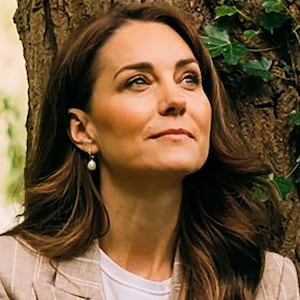 Kate Middleton leans against a tree trunk for portrait.