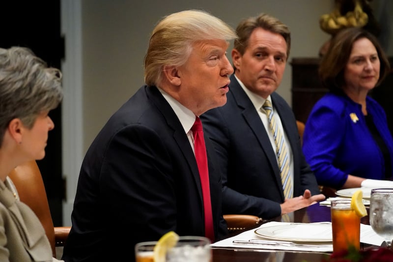 Donald Trump speaks at a table while Jeff Lakes listens next to him.