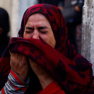 A Palestinian woman reacts at the site of an Israeli strike on a house, after a temporary truce between Hamas and Israel expired, in Khan Younis in the southern Gaza Strip