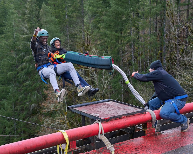 Alt Text: A still of Dotun and Charity from ‘The Bachelorette’ bungee jumping