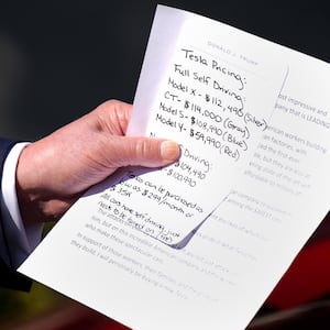 Donald Trump carried a note that included Tesla pricing during his White House stunt where he purchased a new car he says he will never drive.