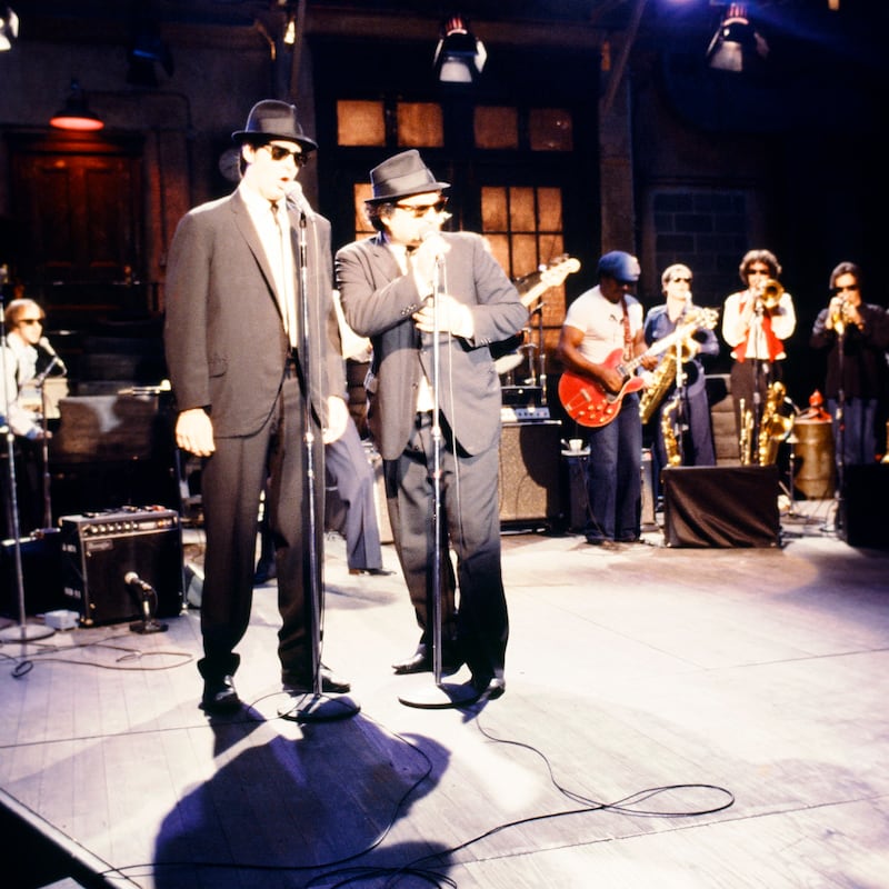 Dan Aykroyd as Elwood Blues, John Belushi as Jake Blues