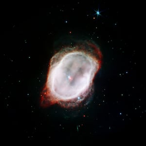 image: The Southern Ring Nebula with stars visible as bright red and blue objects.