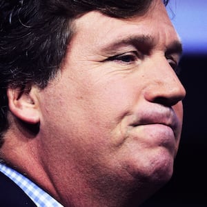  A close up photograph of Tucker Carlson grimacing.