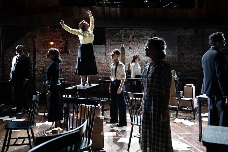 Julia Lester as Miss Marmelstein, standing on table, with the company of “I Can Get It for You Wholesale.”