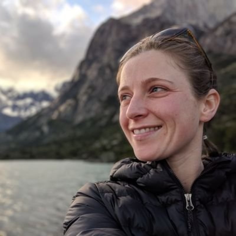 A woman smiling in front of mountains