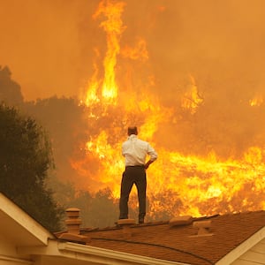 man watching fire flames on his roof carbon emissions global warming ipcc climate change 2 degrees co2 carbon dioxide carbon emissions negative becss bioenergy with carbon capture storage