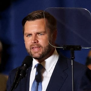 J.D. Vance looks at a teleprompter while speaking on stage.