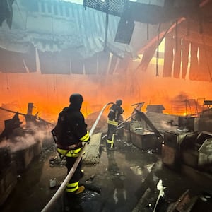 Firefighters work at a site of a household item shopping mall hit by a Russian air strike, amid Russia's attack on Ukraine, in Kharkiv, Ukraine