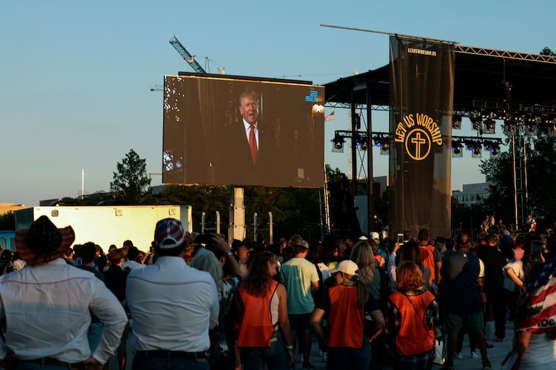 Attendees watch as a video message from former President Donald Trump.