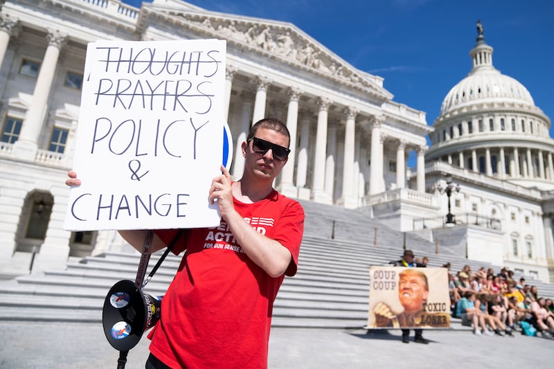 A demonstrator holds a sign referencing calls for legislation to address gun violence outside the U.S. Capitol.