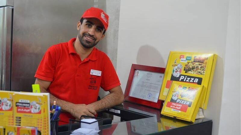 A picture of Abdulrahman Abuamara posing inside his pizzeria