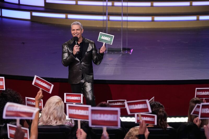 Andy Cohen holding a sign during a segment at Bravocon