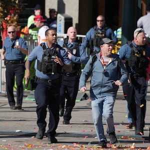 Police run to the scene of a shooting at the Kansas City Chiefs’ Super Bowl parade.