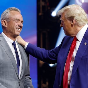 Republican presidential nominee, former U.S. President Donald Trump welcomes Robert F. Kennedy Jr. to the stage at a Turning Point Action campaign rally at the Gas South Arena on October 23, 2024 in Duluth, Georgia.