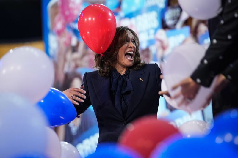 Vice President Kamala Harris laughs as balloons fall after giving her acceptance speech at the Democratic National Convention in Chicago. 