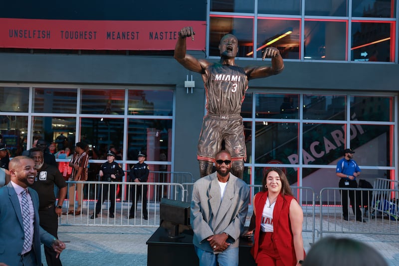 MIAMI, FLORIDA - OCTOBER 28: Dwyane Wade interacts with fans as they visit his statue that was unveiled on October 27th, prior to a game between the Miami Heat and the Detroit Pistons at Kaseya Center on October 28, 2024 in Miami, Florida.  (Photo by Carmen Mandato/Getty Images)