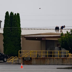 Two FBI investigators scan the roof of AGR International Inc, the building adjacent to the Butler Fairgrounds, from which alleged shooter Matthew Thomas Crooks fired at former President Donald J. Trump