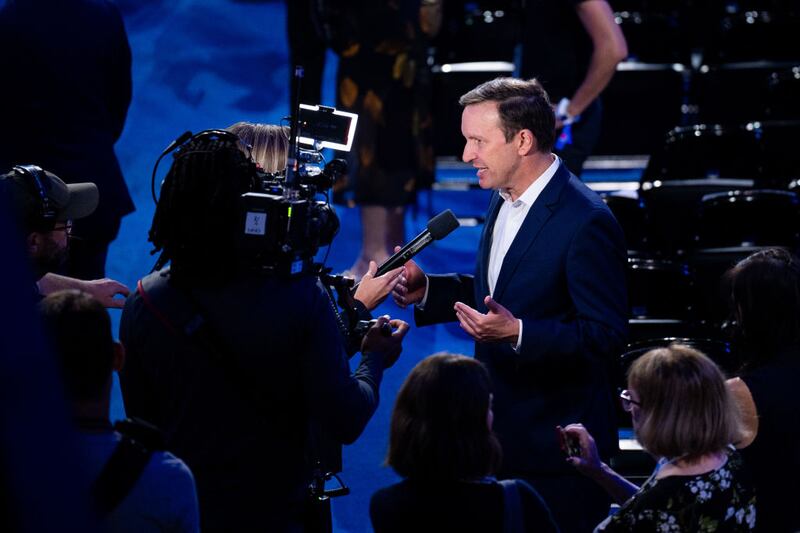 Sen. Chris Murphy speaks to a TV news reporter on the convention floor before the start of the final day of the 2024 Democratic National Convention in Chicago.