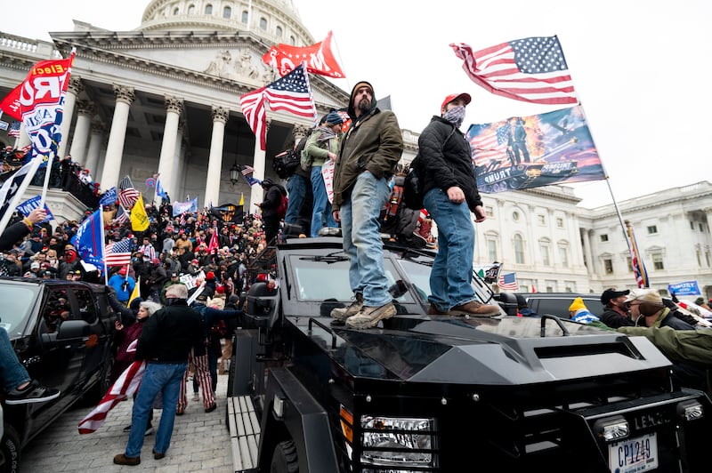 Trump supporters stand on a U.S. Capitol Police armored vehicle on Jan. 6, 2021.