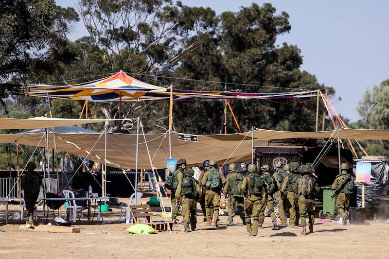 Israeli soldiers walk through the site of an attack on the Nova Festival by Hamas.