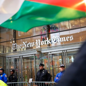 A Palestinian flag being waved in front of New York Times building.