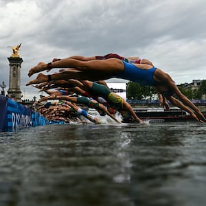 The women dive into the Seine at the start of the triathlon