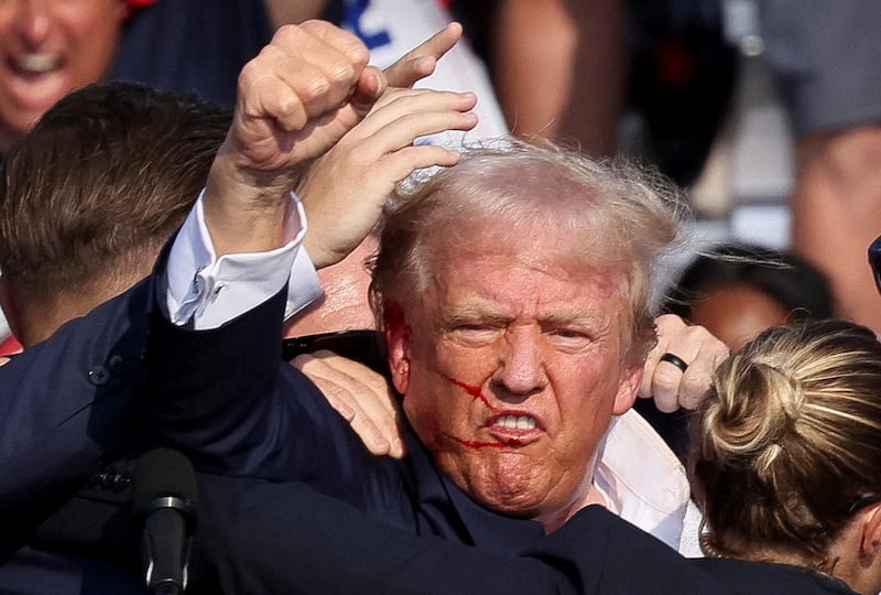 Trump fist pumping close up blood running down his face