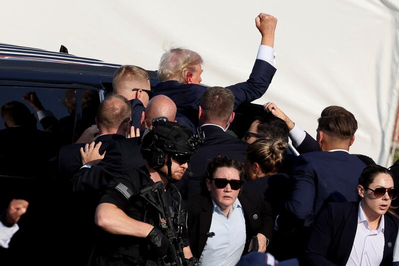 Donald Trump gestures as he gets into a vehicle 