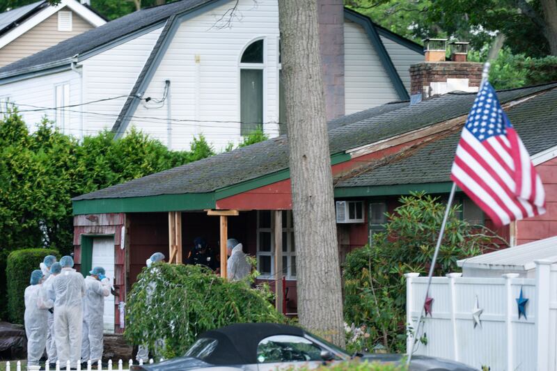 Crime laboratory officers seen arriving at the suspect’s Massapequa Park home.