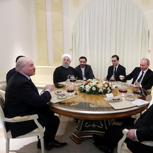 Russian President Vladimir Putin, Iranian President Hassan Rouhani, Turkish President Recep Tayyip Erdogan and President of Belarus Alexander Lukashenko sitting together at a table.