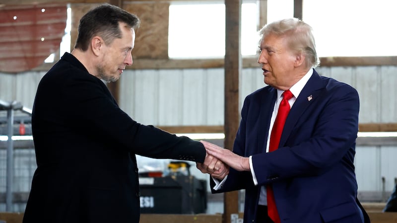 Elon Musk shakes hands with Republican presidential nominee, former President Donald Trump back stage during a campaign rally at the Butler Farm Show grounds on October 05, 2024 in Butler, Pennsylvania.