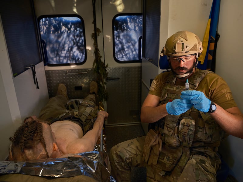 Mathew, right, treats an injured Ukrainian soldier nicknamed Cossack.