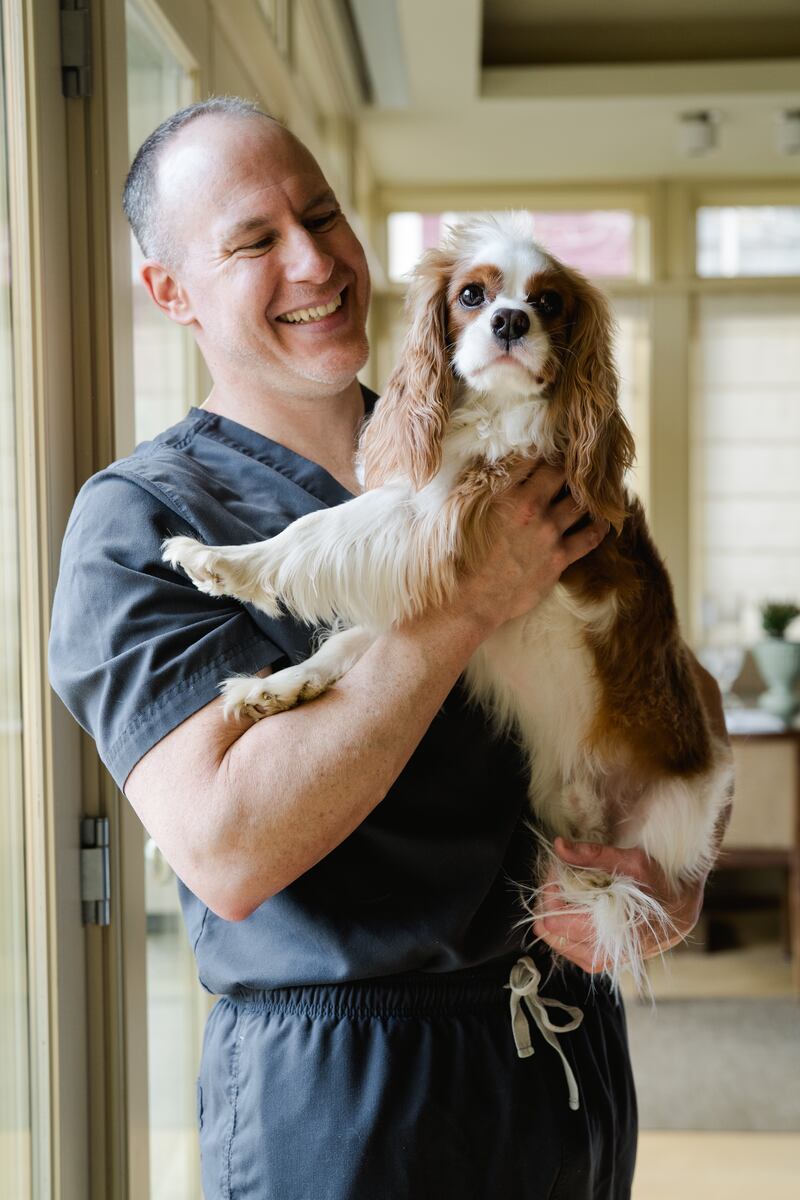 A man in scrubs and his dog. 