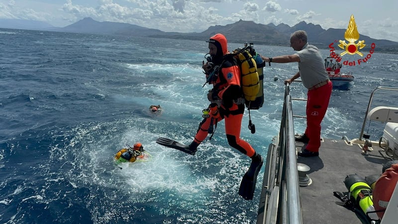 Divers jump into the ocean near the crash site of the Bayesian.