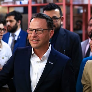 Kamala Harris and Josh Shapiro smiling with a crowd behind them 