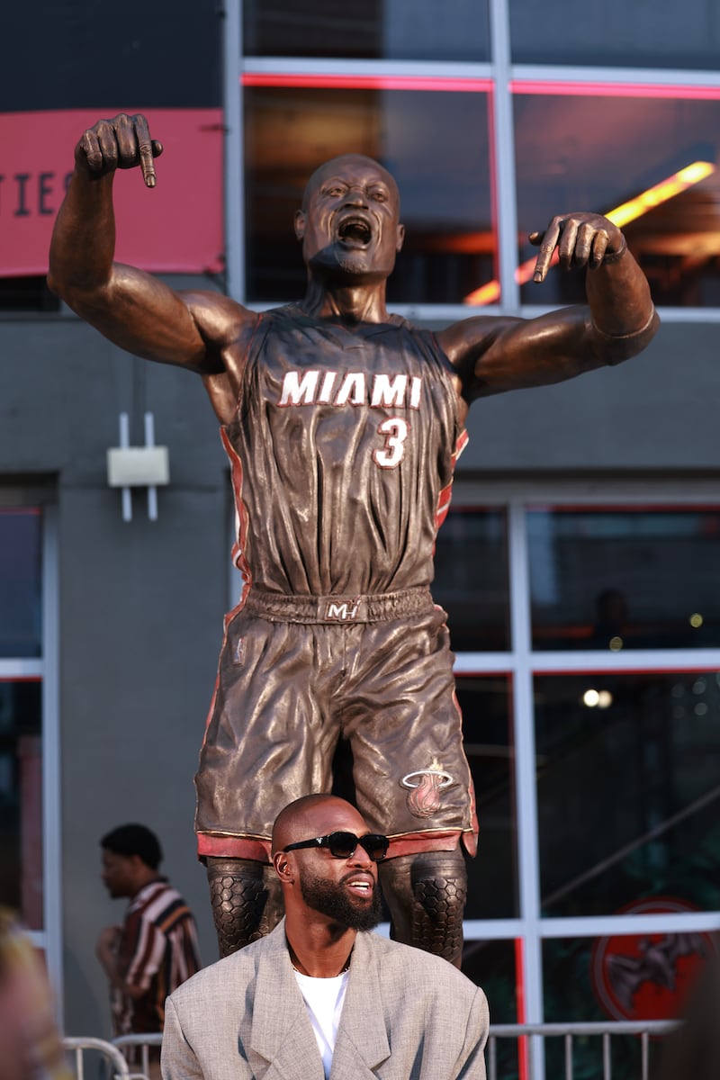 MIAMI, FLORIDA - OCTOBER 28: Dwyane Wade interacts with fans as they visit his statue that was unveiled on October 27th, prior to a game between the Miami Heat and the Detroit Pistons at Kaseya Center on October 28, 2024 in Miami, Florida.  (Photo by Carmen Mandato/Getty Images)