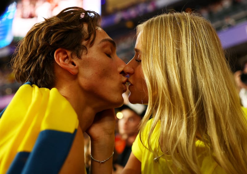 Mondo Duplantis celebrates his pole vault victory with a kiss from his girlfriend, Desire Inglander, at the Paris Olympics on August 5, 2024.