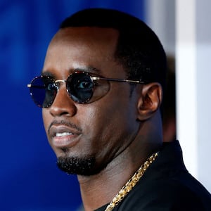 Sean Combs, wearing glasses, stares to his side.