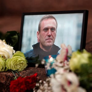 Flowers and a candle are placed next to a portrait of Russian opposition leader Alexei Navalny following Navalny’s death.