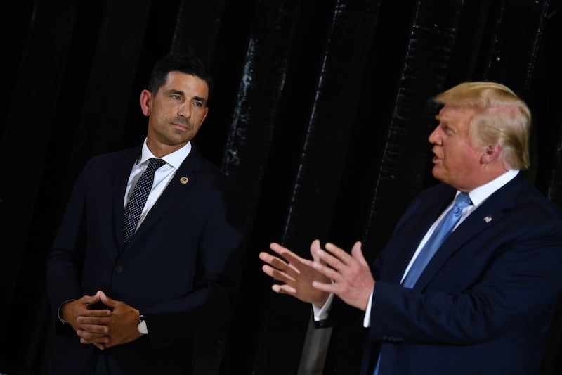 Former president Donald Trump delivers remarks as former Acting secretary of Homeland Security, Chad Wolf (L) looks on at the international airport in Yuma, Arizona on August 18, 2020.